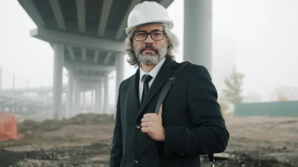 Zpomalený portrét vedoucího stavebního projektu stojící na staveništi — Stock video