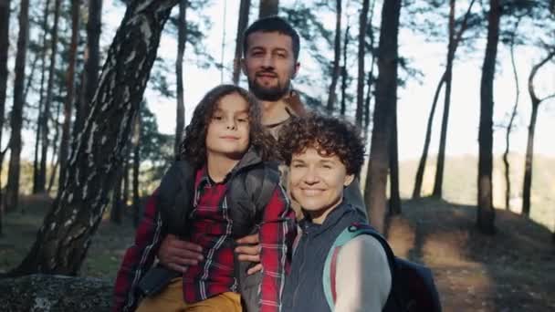 Zeitlupe Porträt einer glücklichen Familie mit Vater und Sohn, die mit Rucksäcken im Wald steht — Stockvideo