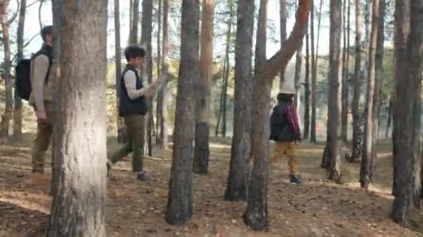 Seitenansicht des Mannes Frau und Kind wandern in Wäldern mit Karte genießen Reisen im Freien — Stockvideo