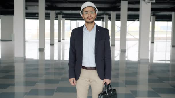 Retrato de investidor de construção ambicioso em capacete e terno de pé em planta vazia — Vídeo de Stock
