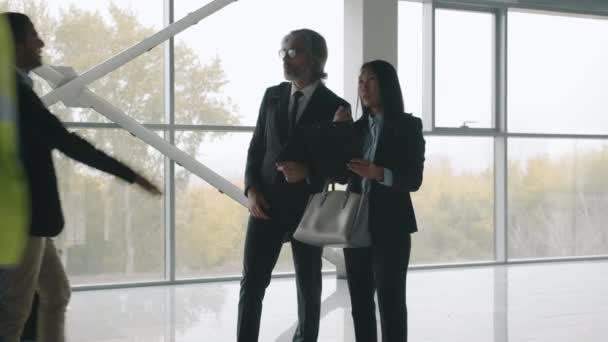 Biznesmeni spotykają się w nowym centrum biurowym, uściskując dłonie, omawiając wynajem nieruchomości — Wideo stockowe
