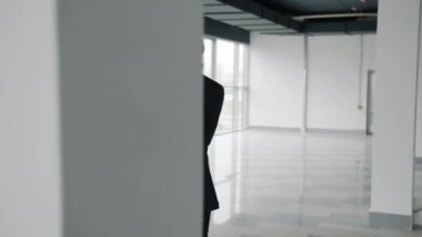 Olgun iş adamı boş ofis merkezinde cep telefonuyla konuşuyor.