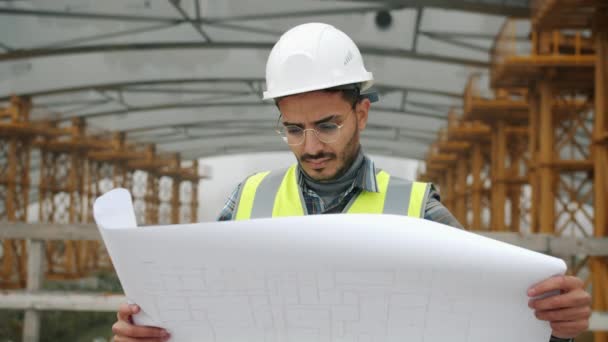 Portrait d'un employé de la construction du Moyen-Orient portant l'uniforme étudiant le plan directeur à l'extérieur — Video