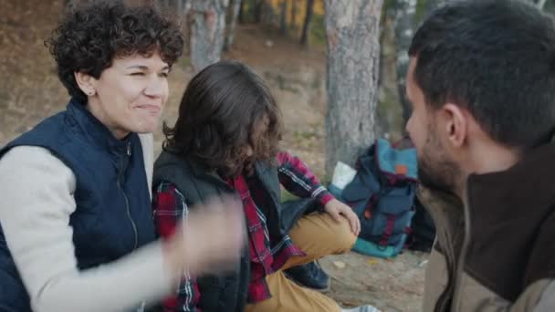 Mann Frau und Kind reden und essen Mais und haben Spaß beim Picknick im Wald — Stockvideo
