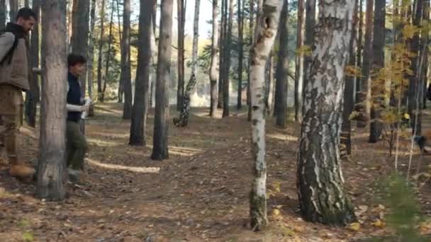 Hombre y mujer turistas caminando en el bosque con el niño haciendo high-five — Vídeos de Stock