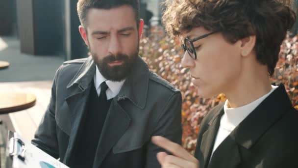 Homem e mulher em roupas formais conversando sobre negócios em café ao ar livre — Vídeo de Stock