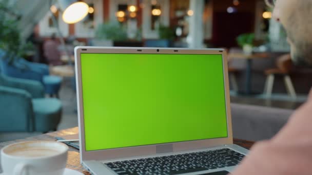 Cámara lenta del hombre mirando la pantalla verde croma pantalla verde clave en la cafetería — Vídeos de Stock