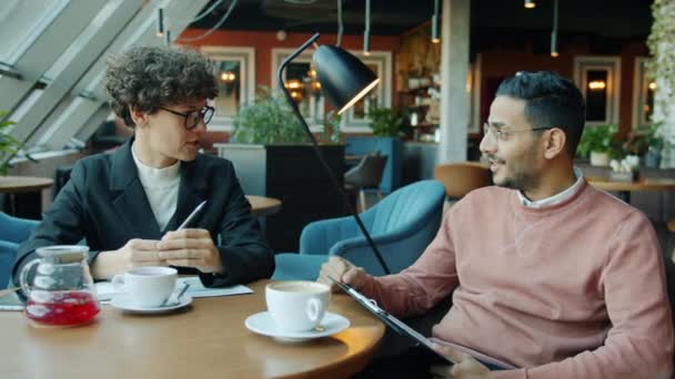 Бизнесмены разговаривают во время неформальной встречи в кафе — стоковое видео
