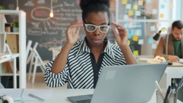 Retrato de una ambiciosa empresaria afroamericana quitándose las gafas y sonriendo en la oficina — Vídeos de Stock