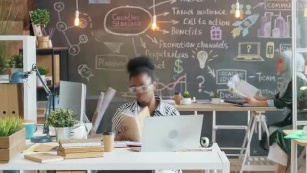 Zoom-out tijd verstrijken van het bedrijfsleven mannen en vrouwen werken met laptops en praten in creatief kantoor — Stockvideo