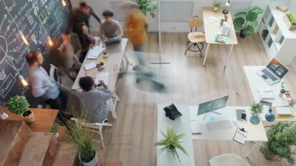 Zoom-en vista de ángulo alto del equipo creativo que trabaja en la oficina compartida que habla cooperando — Vídeo de stock