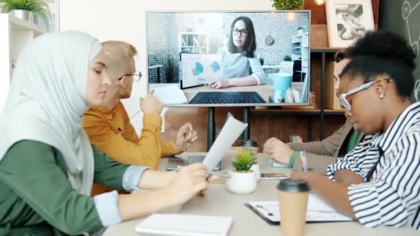 Groupe d'employés parlant à une collègue pendant un appel vidéo sur le lieu de travail — Video