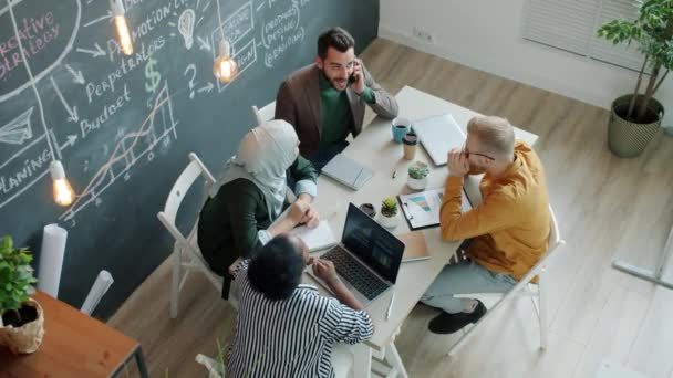 Fröhliche Mitarbeiter, die gute Nachrichten auf dem Handy bekommen, lachen bei High-Five im Büro — Stockvideo