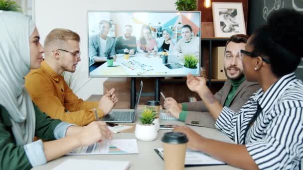 İş yerindeki video görüşmeleri sırasında çok ırklı çalışma arkadaşlarıyla konuşan yaratıcı iş ekibi — Stok video
