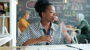 Neşeli Afro-Amerikalı iş kadını konuşuyor gülümsüyor, alkışlıyor ofisteki video görüşmesinin keyfini çıkarıyor.
