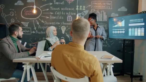 Oddálit kreativní týmové sdílení nápadů mluvení sledování digitální prezentace v kanceláři s tabulovou stěnou — Stock video