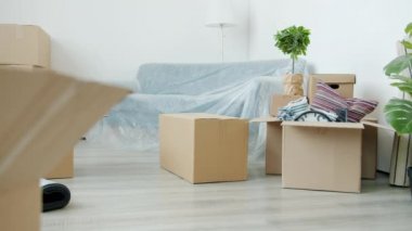Esmer bir adamın yeni daireye karton kutular getirirken görüntüsü düşük.