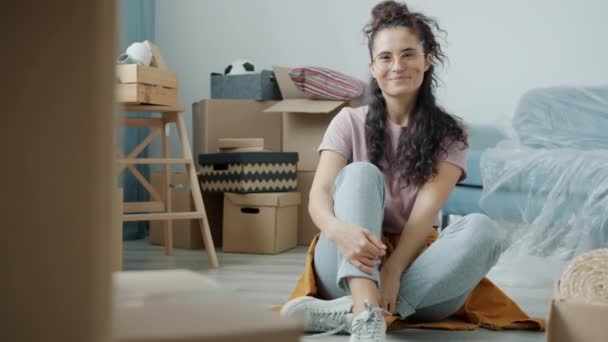 亚洲美女笑着坐在新公寓地板上的慢动作肖像 — 图库视频影像