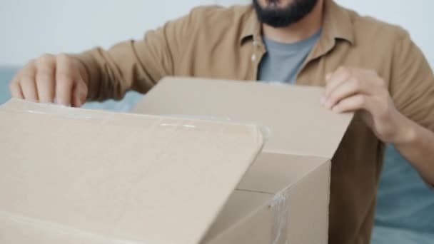 Închiderea mâinilor de sex masculin deschiderea cutiei de carton despachetarea lucrurilor în timpul relocării — Videoclip de stoc