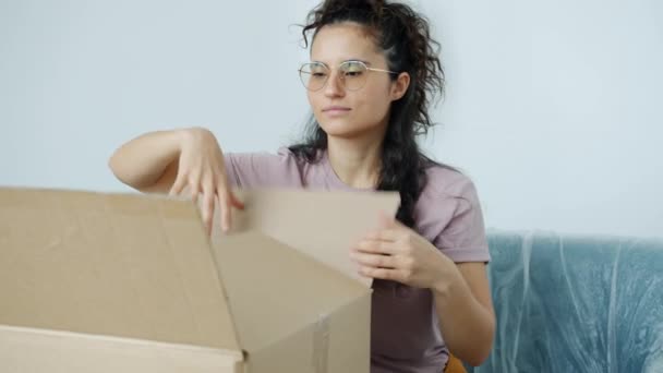 Zeitlupe einer gut aussehenden Mischlingshündin beim Auspacken von Kartons in neuem Haus — Stockvideo