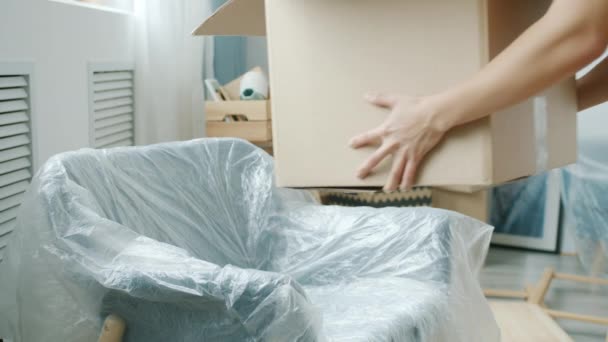 Großaufnahme weiblicher Hände, die einen Karton mit Sachen in ein neues modernes Haus bringen — Stockvideo