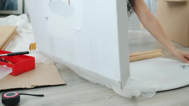 Κοντινό πλάνο των γυναικών χέρια εγκατάσταση τραπέζι κατά τη διάρκεια της μετεγκατάστασης σε νέο διαμέρισμα — Αρχείο Βίντεο