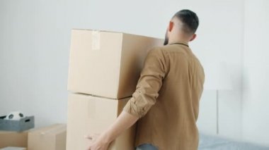 Yeni modern apartmanda karton kutular taşıyan melez ırkın arka planı.