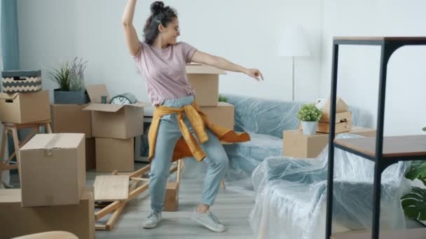 Vreugdevolle gemengde ras vrouw dansen in nieuwe moderne appartement tijdens de verhuizing — Stockvideo