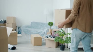 Yakışıklı Orta Doğulu adamın yeni eve karton kutular getirmesi yavaş bir hareket.