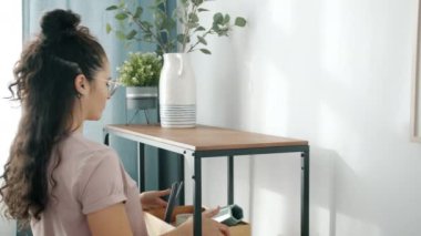 Yaratıcı kız iç dekorasyon. Taşınırken eşyaları ahşap raflara koyuyor.