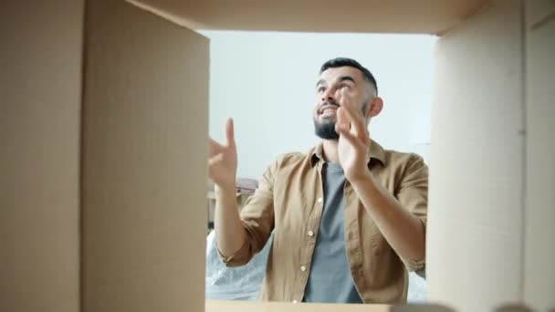 Glada Mellanöstern kille packa upp saker boll och böcker från kartong i nytt hus — Stockvideo