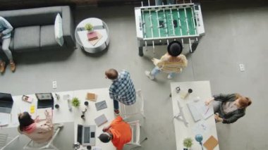 Modern iş adamlarının ve kadınların masa futbolunda rahat ve çalışkan çalışmalarının en üst görüşü