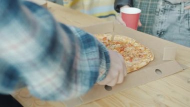 İş adamları ofiste yemek yerken kadın ve erkeğin ellerinin pizza dilimlerini yakın plan çekimleri.