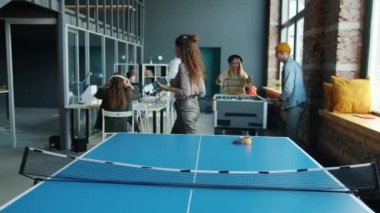 Meslektaşlar langırt oynarken ortak ofiste çalışan hırslı genç girişimciler.