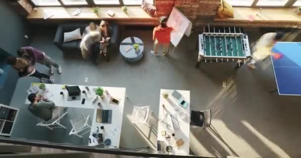 Вид зверху проміжок часу співробітників компанії, що працюють у спільному офісі в сонячний день, рухаючись навколо — стокове відео