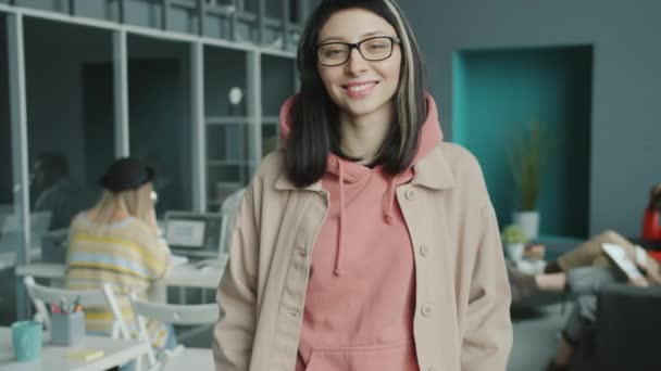 Fiatal női alkalmazott áll a modern coworking center mosolygós visel alkalmi ruhák — Stock videók