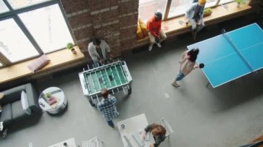Modern çalışma ortamında langırt ve masa tenisi oynayan meslektaşların en üst görünümü