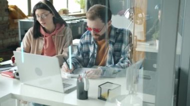 İşletme hocası genç stajyerle konuşuyor. Ofisteki yeni projeyi anlatıyor.
