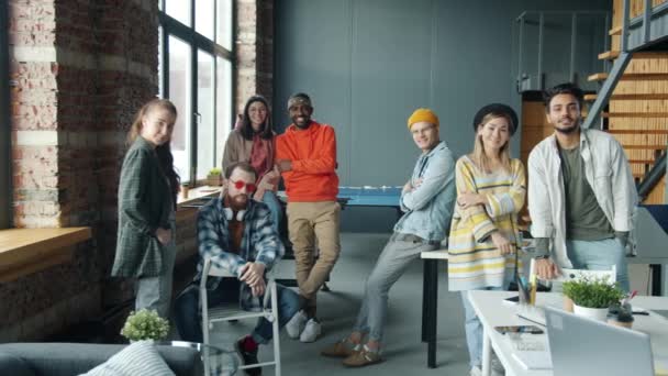 Медленный портрет мужчин и женщин, стоящих на рабочем месте, улыбающихся в модном наряде — стоковое видео