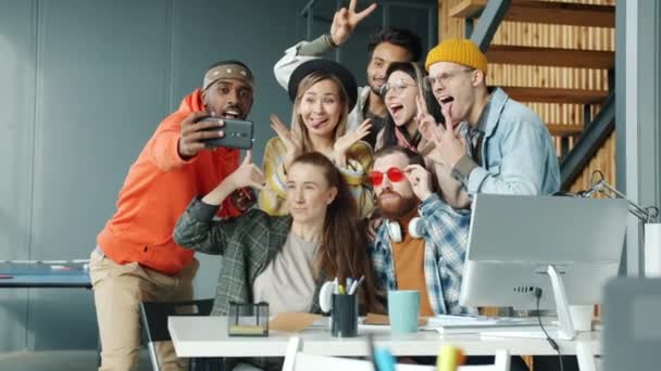 Grupo multiétnico de empleados se toman selfie en el trabajo posando y divirtiéndose en la oficina moderna — Vídeos de Stock