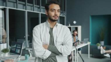 Orta Doğulu yöneticinin yavaş çekimde kameraya dönüp kapalı alanda gülümsemesi.