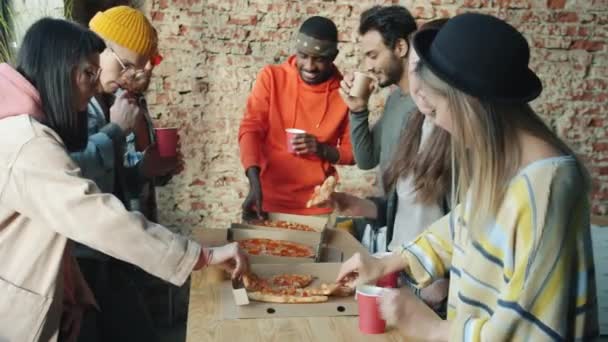 Gruppo multietnico di uomini d'affari che mangiano pizza insieme in un moderno ufficio in stile loft — Video Stock