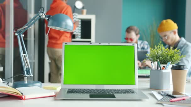 Медленное движение современного ноутбука с зеленым цветным экраном на рабочем столе — стоковое видео