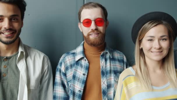 Retrato de jóvenes empresarios alegres de pie sobre fondo de color negro sonriendo — Vídeos de Stock