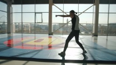 Modern spor salonunda boks hareketleri yapan sağlıklı genç bir kadın.