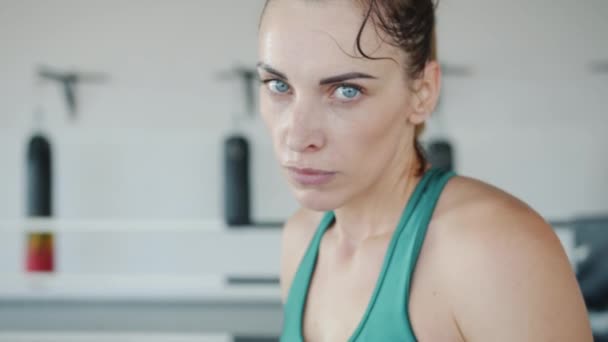 Retrato em câmera lenta de boxeador feminino cansado e suado pulando no ringue olhando para a câmera — Vídeo de Stock