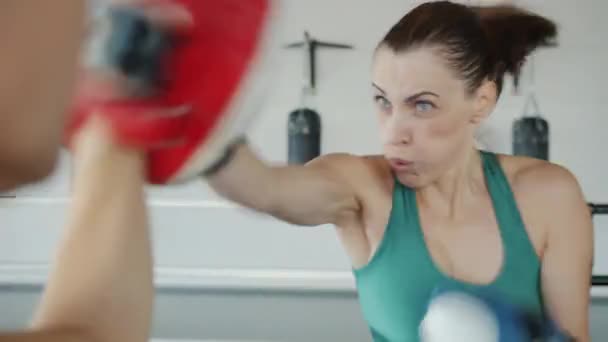 Silná mladá dívka trénink punče v tělocvičně na sobě boxerské rukavice a uniformu — Stock video