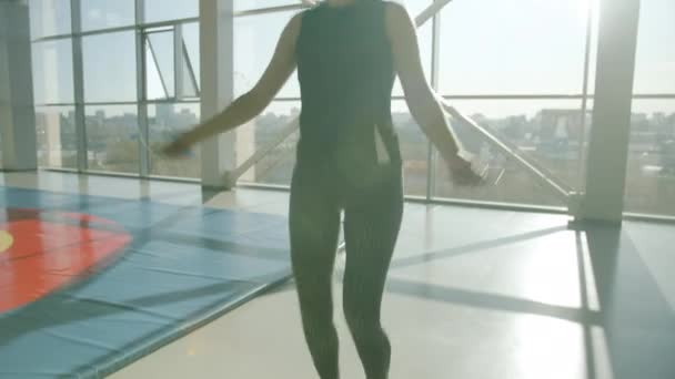 Ženské studentské školení v interiéru skákání s skákání provaz sám na sobě moderní sportovní oblečení — Stock video