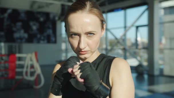 Slow motion porträtt av dedikerad MMA fighter står i gym med inslagna händer och tittar på kameran — Stockvideo