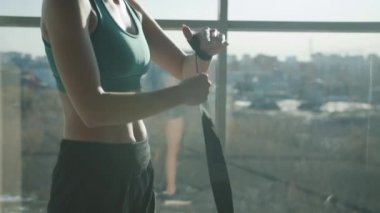 Güzel genç sporcu kadın eğitime hazırlanıyor koruyucu kayışlarla sarılı eller